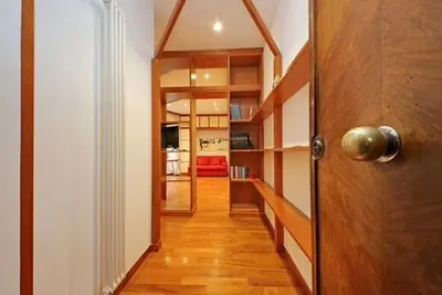 a hallway with a door and a room with shelves at Porta Metronia Suite in Rome