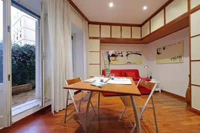 a dining room with a table and a red couch at Porta Metronia Suite in Rome