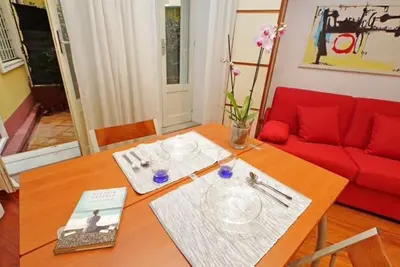 a living room with a table and a red couch at Porta Metronia Suite in Rome