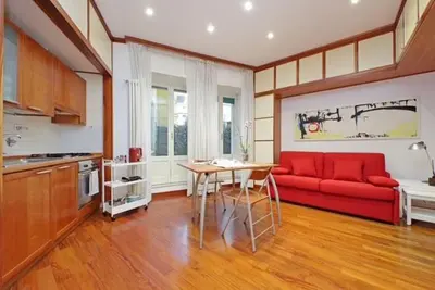 a living room with a red couch and a table at Porta Metronia Suite in Rome