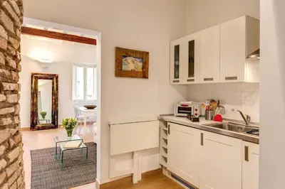 a kitchen with white cabinets and a sink at NEW Navona Bright Apartment in Rome