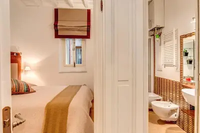 a bedroom with a bed and a bathroom with a sink at NEW Navona Bright Apartment in Rome