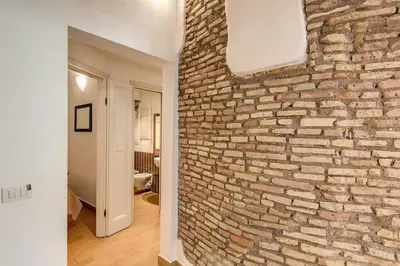 a room with a stone wall with a window at NEW Navona Bright Apartment in Rome