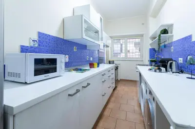 a kitchen with white counters and blue tiles at Anastasia Comfort at the Vatican with Balcony in Rome
