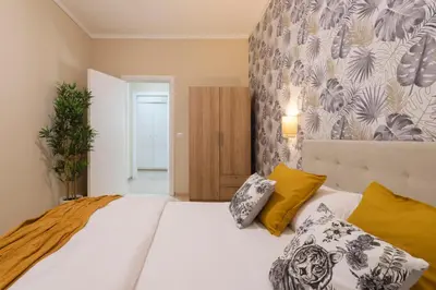 a bedroom with a large white bed with yellow pillows at Anastasia Comfort at the Vatican with Balcony in Rome