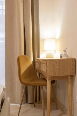 a wooden desk with a chair next to a lamp at Anastasia Comfort at the Vatican with Balcony in Rome
