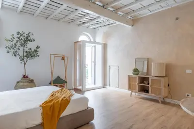 a bed with white sheets and a yellow blanket at Eos Retreat in Trastevere with pool in Rome
