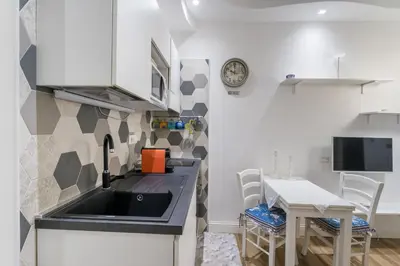 a kitchen with a sink and a table with chairs at Cozy apartment in Trastevere with patio - AC in Rome