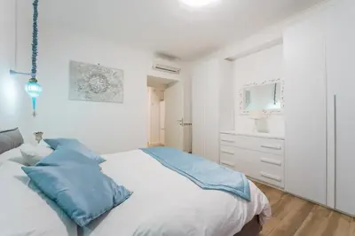 a white bedroom with a bed with blue pillows at Cozy apartment in Trastevere with patio - AC in Rome