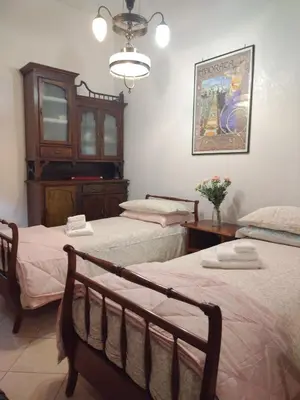 a bedroom with two beds and a chandelier at Camilla's House in Rome