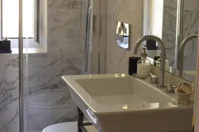 a white bathroom with a sink and a shower at Piano Suite in Vatican in Rome
