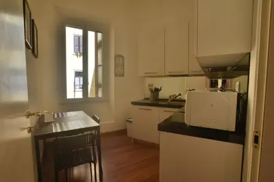 a kitchen with white cabinets and a counter top at Piano Suite in Vatican in Rome