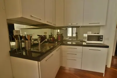 a kitchen with white cabinets and a sink and a microwave at Piano Suite in Vatican in Rome