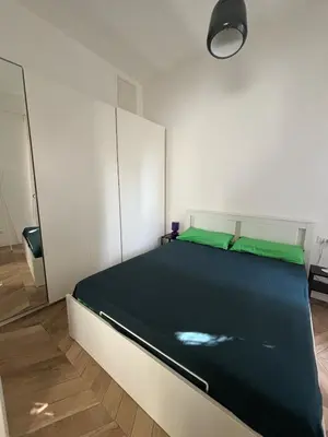 a bedroom with a large bed with green sheets at Casa Mari - Cozy Apartment San Paolo Rome in Rome