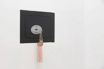 a clock on a wall with tassles on it at CasAchille Mini Studio in Rome