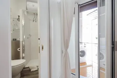 a bathroom with a toilet and a washing machine at CasAchille Mini Studio in Rome