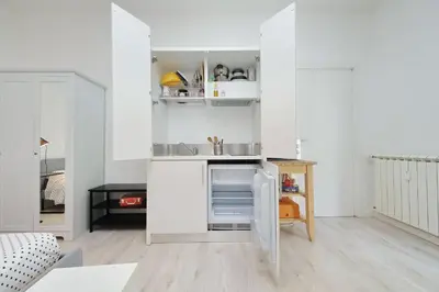 a small kitchen with white cabinets and a sink at CasAchille Mini Studio in Rome