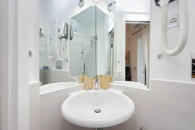 a white bathroom with a sink and a shower at CasAchille Mini Studio in Rome