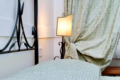 a lamp sitting next to a bed with a curtain at Scipioni Suites in Rome