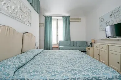 a bedroom with a bed and a couch and a television at Scipioni Suites in Rome