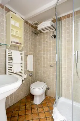 a bathroom with a toilet and a sink and a shower at Scipioni Suites in Rome