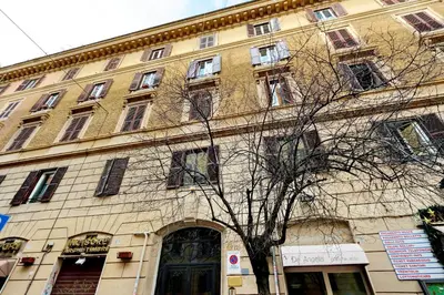 a large building with a tree in front of it at Scipioni Suites in Rome