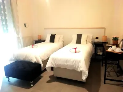 a bedroom with two beds and a desk at Gianicolense Holiday Suite-Apartment in Rome