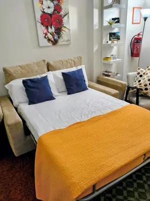 a bedroom with a large bed and a couch at Gianicolense Holiday Suite-Apartment in Rome