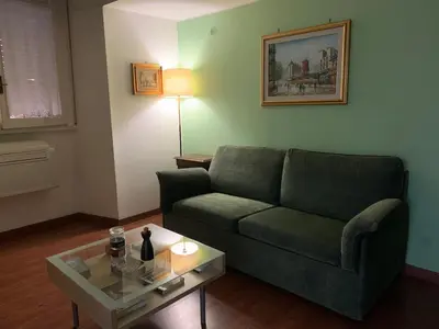 a living room with a green couch and a table at Apartment in historic palace in Rome