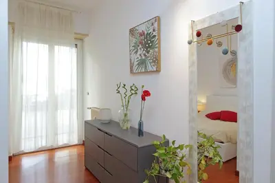 a room with a dresser with flowers on it at Modern Apartment near Metro Malatesta with Balcony & Wi-Fi in Rome