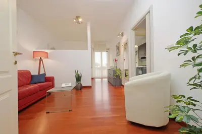 a living room with a red couch and a red chair at Modern Apartment near Metro Malatesta with Balcony & Wi-Fi in Rome