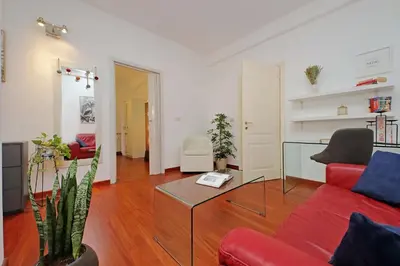 a living room with a red couch and a table at Modern Apartment near Metro Malatesta with Balcony & Wi-Fi in Rome