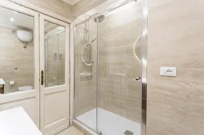 a shower with a glass door in a bathroom at Vatican Penthouse - Terrace with view in Rome