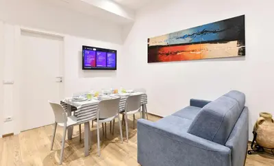 a dining room with a table and a blue couch at Testaccio Dream House in Rome
