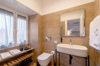 a bathroom with a sink and a toilet and a mirror at Casa Barbieri boutique apartment Borgo Pio in Rome