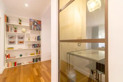 a glass door leading into a room with bookshelves at Casa Barbieri boutique apartment Borgo Pio in Rome