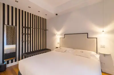 a bedroom with a large white bed and a window at Casa Barbieri boutique apartment Borgo Pio in Rome