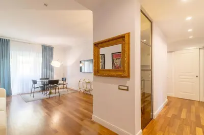 a living room with white walls and a mirror at Casa Barbieri boutique apartment Borgo Pio in Rome