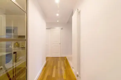 a hallway with white walls and a glass door at Casa Barbieri boutique apartment Borgo Pio in Rome