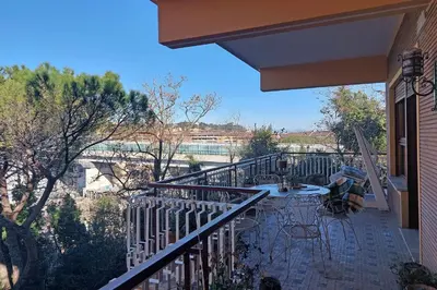 a balcony of a house with a table and chairs at Anastasio Spacious Apartment in Rome