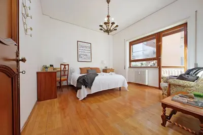 a bedroom with a bed and a table and a window at Anastasio Spacious Apartment in Rome