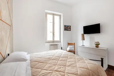 a white bedroom with a large bed and a television at Vaticano San Pietro - Marisa Home - Check-in h24 in Rome