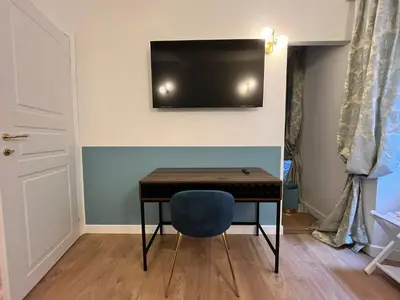 a room with a table and a television on a wall at Paolina Place in Rome
