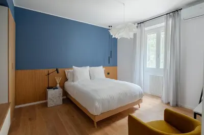 a bedroom with a bed and a blue wall at Cereate Suites in Rome