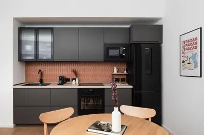 a kitchen with a table and a black refrigerator at Cereate Suites in Rome