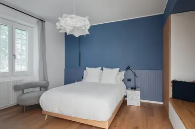 a bedroom with a white bed and a blue wall at Cereate Suites in Rome