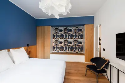 a bedroom with a white bed and a blue wall at Cereate Suites in Rome