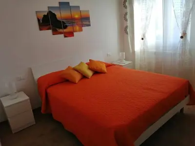 a bedroom with a orange bed with two pillows at Art House Vatican Elegante appartamento Centrale in Rome