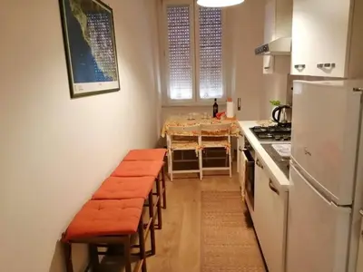 a kitchen with a table and chairs and a white refrigerator at Art House Vatican Elegante appartamento Centrale in Rome