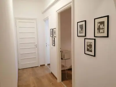 a hallway with a white door and pictures on the wall at Art House Vatican Elegante appartamento Centrale in Rome